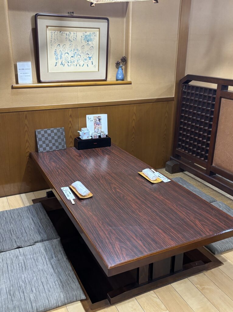 A cozy Japanese-style room with a sunken kotatsu table and traditional decor
