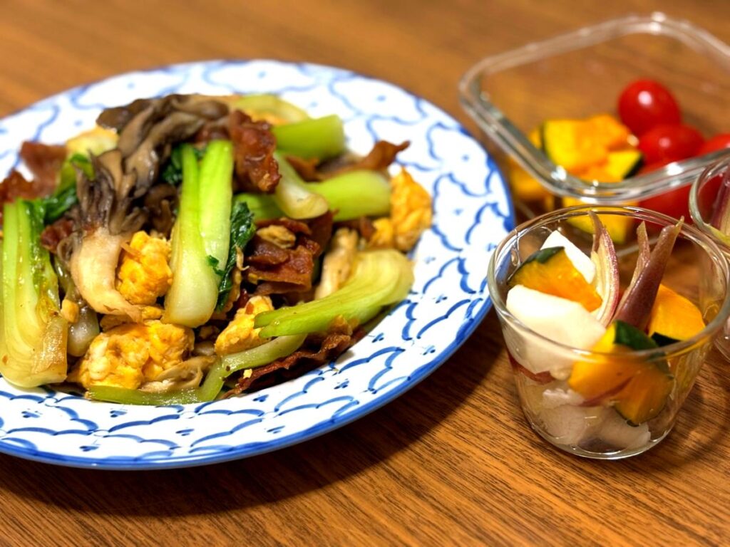 Stir-fried bok choy with maitake mushrooms and eggs, served with a colorful pickle medley
