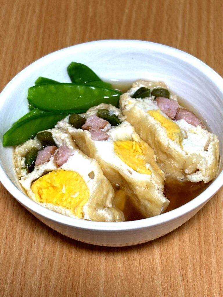 Simmered tofu pouches cut in half and served with snow peas.