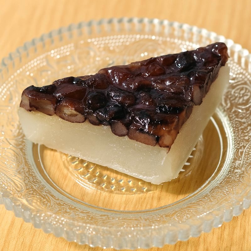 A triangular slice of Minazuki sweet beautifully served on a glass plate.