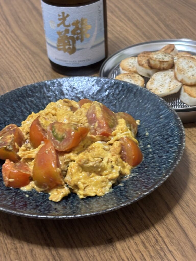 Tomato and scrambled egg stir-fry with sautéed yam. Koueigiku “Sukai” sake bottle in the background.