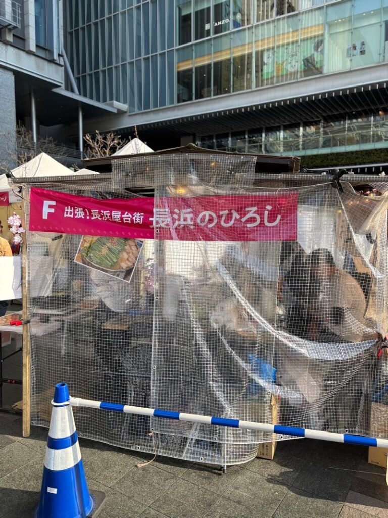"Nagahama no Hiroshi" food stall at Kyushu Sake Brewery Opening. The lively atmosphere inside the plastic-covered stall.