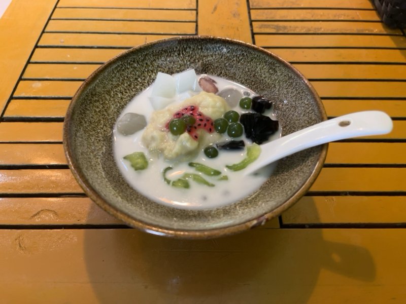 Traditional Vietnamese dessert “Chè”, a colorful sweet with mung beans, fruits, and agar jelly in coconut milk.