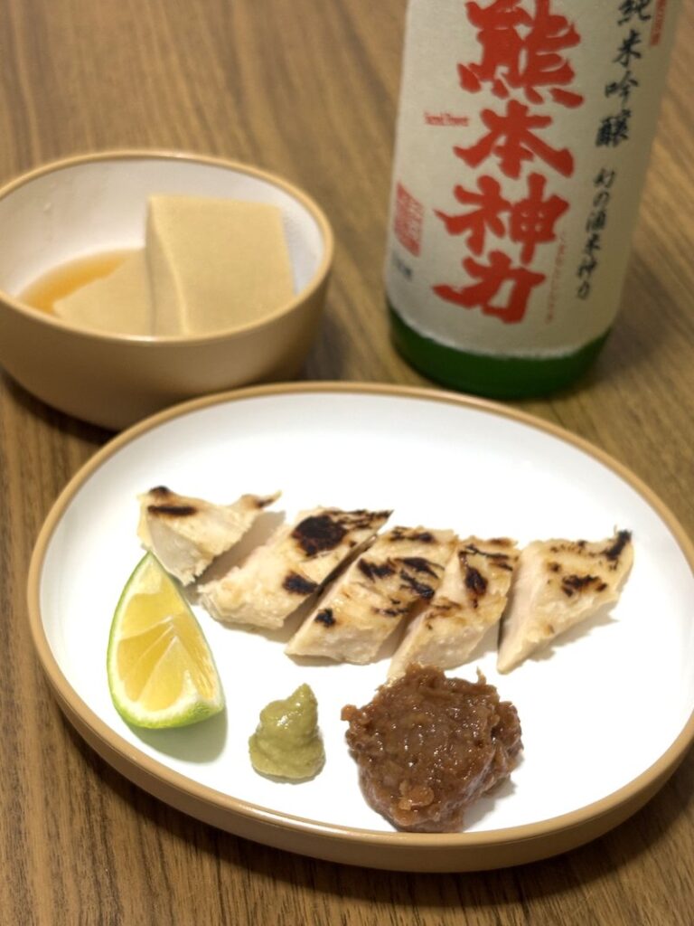 Junmai Ginjo “Kumamoto Shinriki” with a dinner setting. Grilled chicken tenderloin with shio-koji, simmered koya-dofu, and condiments on the plate.