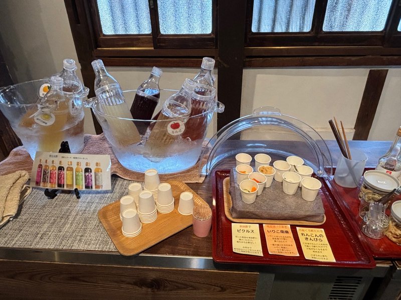 Tasting corner inside Shobunzu, featuring vinegar drinks chilled on ice and small tasting cups with samples.