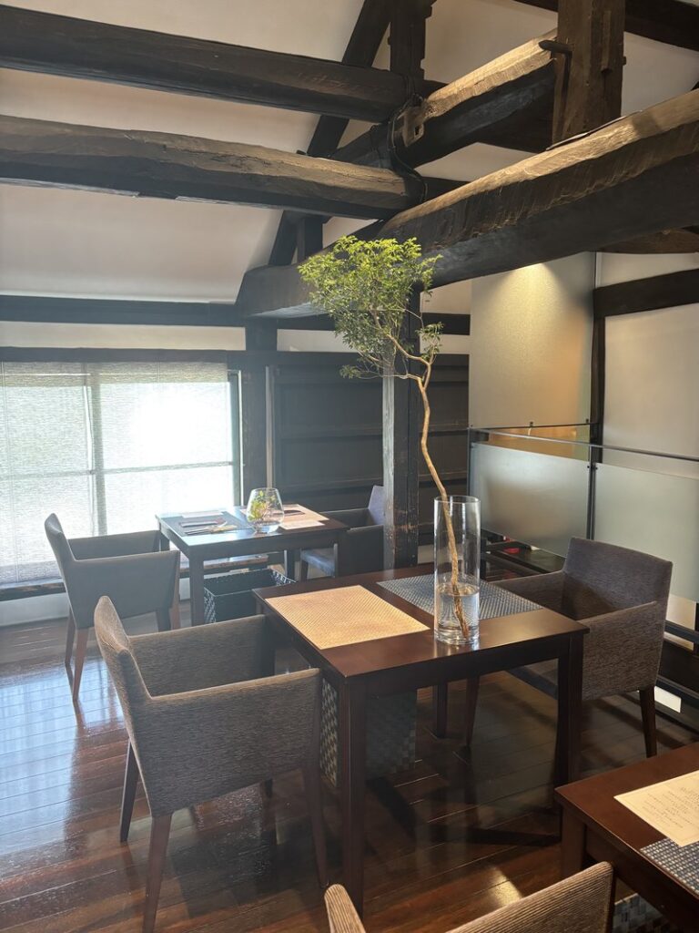 Interior of Shobunzu restaurant with wooden beams and neatly arranged tables in a calm atmosphere.