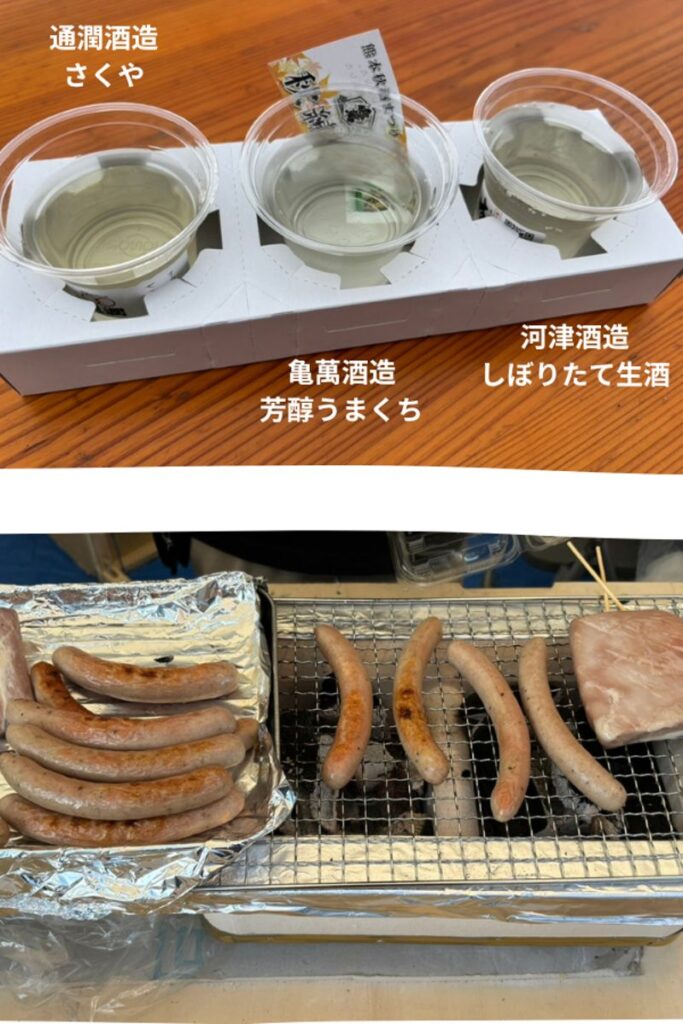 Three cups of sake from KameMan Brewery, Tsūjun Brewery, and Kawazu Brewery with sausages grilling over charcoal at the Kumamoto Autumn Sake Festival.
