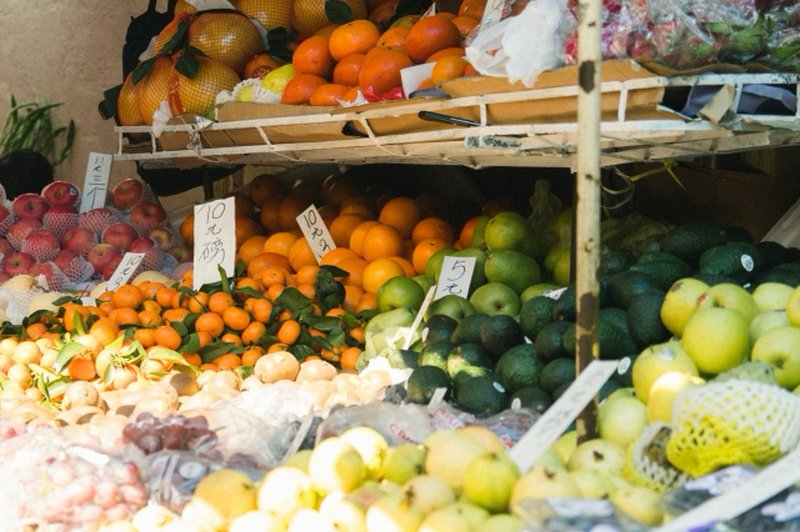 Colorful seasonal fruits such as apples and citrus displayed at a fruit market in Macau.