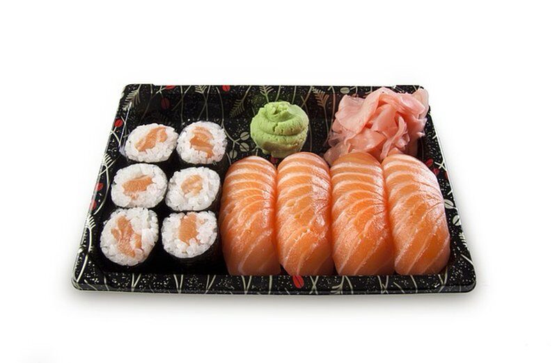 A sushi platter featuring salmon nigiri and salmon maki rolls