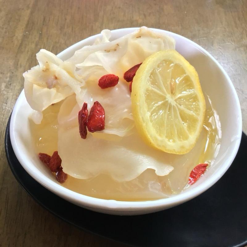A translucent dessert made with white wood ear fungus, lemon slices, and goji berries.