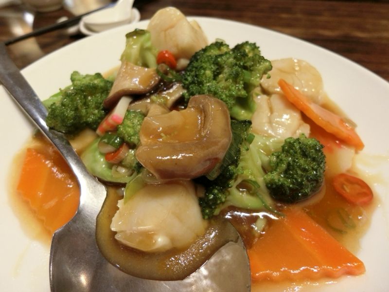 Chinese-style stir-fried scallops with vegetables served on a plate