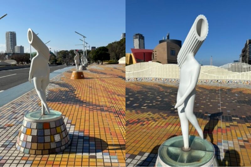 Sculptures titled “Spirits of the Seven Cosmic Days” lined along a pedestrian walkway near Tanga Market, featuring white figures with pasta-shaped heads