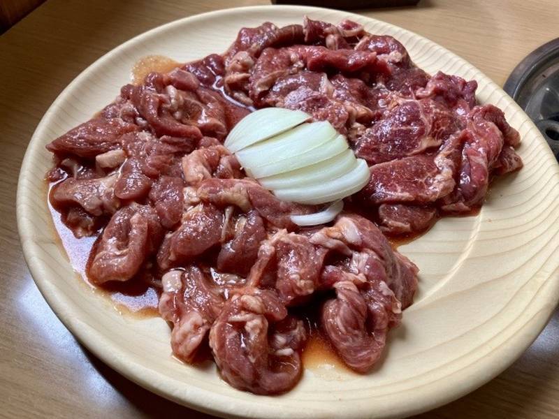 Lamb meat marinated in sauce for jingisukan, served with sliced onions.
