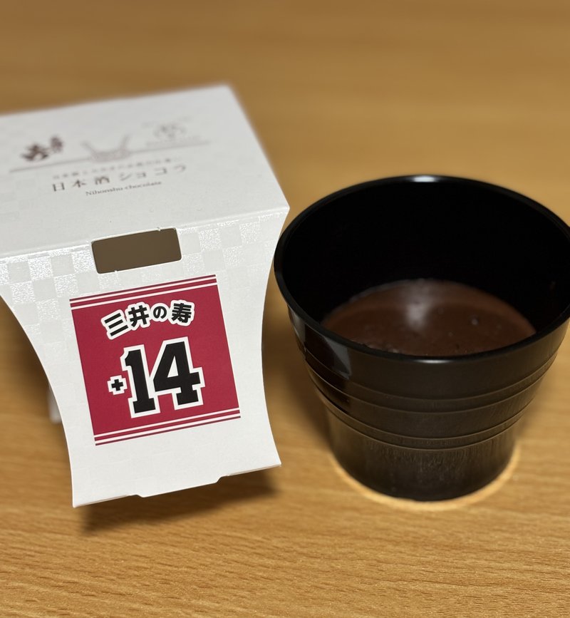 A bottle of "Mii no Kotobuki"sake alongside a rich chocolate gateau,"Nihonshu Chocolat"