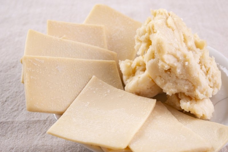 Sake lees showing both firm sheet-like kasu and soft paste-like kasu on a plate