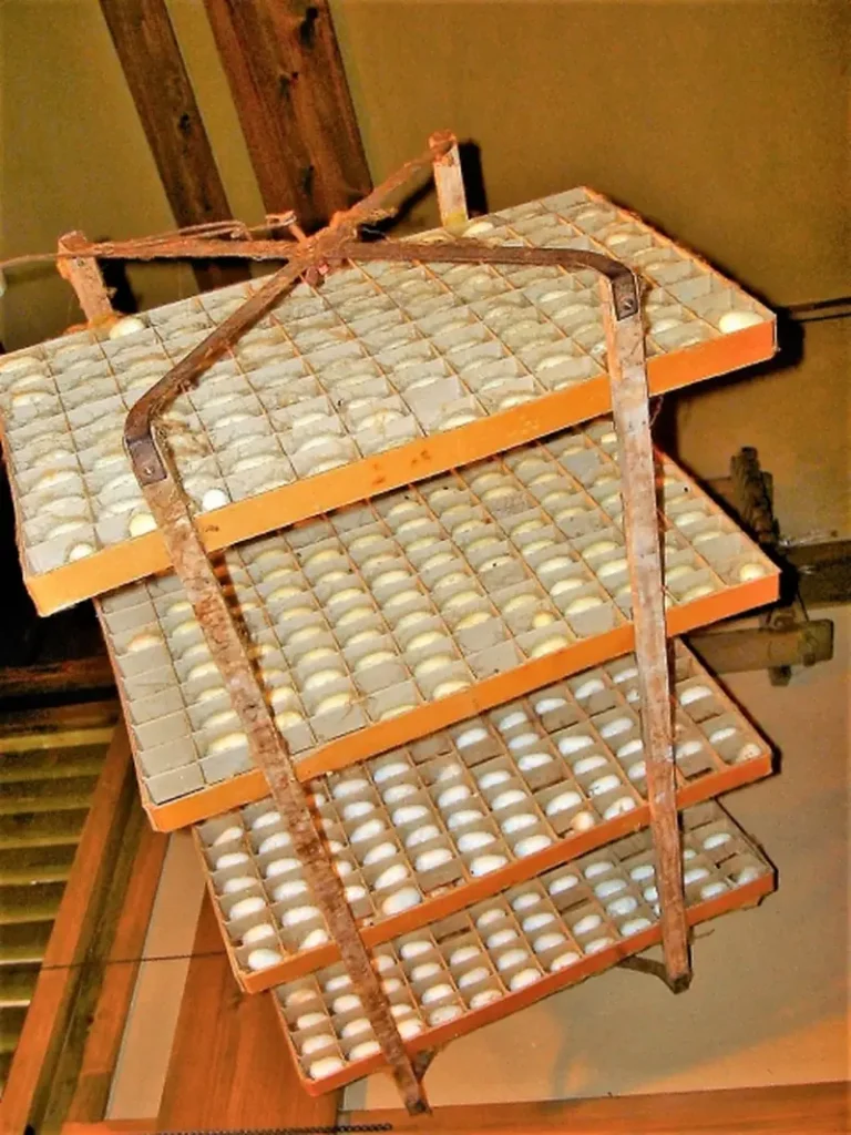 ld wooden shelving stacked with traditional wooden cocoon frames used in silkworm farming