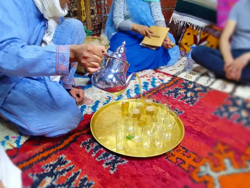 A glass of mint tea with fresh mint leaves floating on top.
