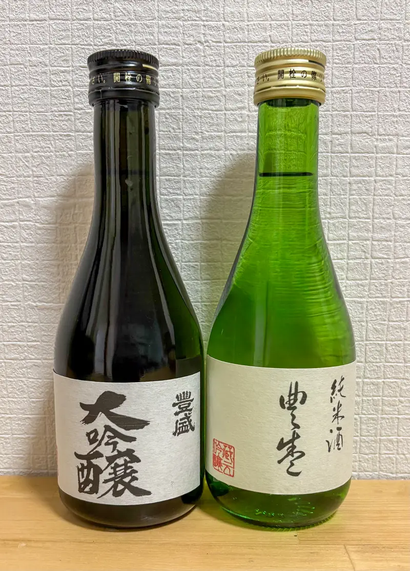 Two bottles of "Toyosakari" sake from Toyomura Brewery — a daiginjo and a junmai — displayed side by side.